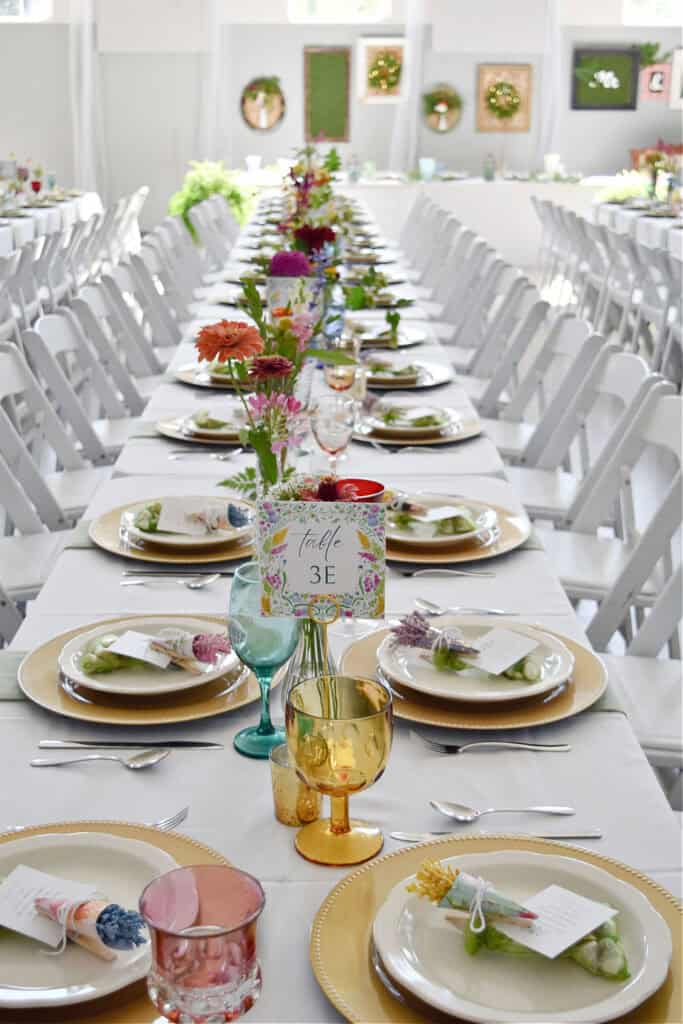 Colorful garden party themed wedding decor on long table.