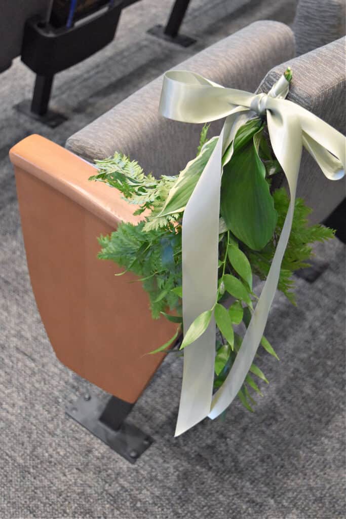 Pew floral greens arrangement for wedding ceremony.