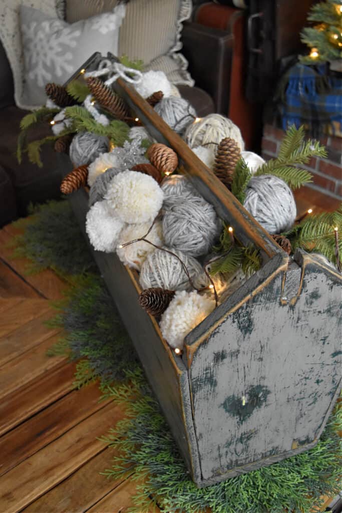 Yarn balls and poms in tool caddy as winter decor.