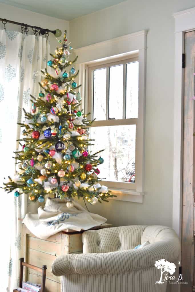 Vintage Shiny Brite ornaments fill a tree in a Christmas decorated kitchen