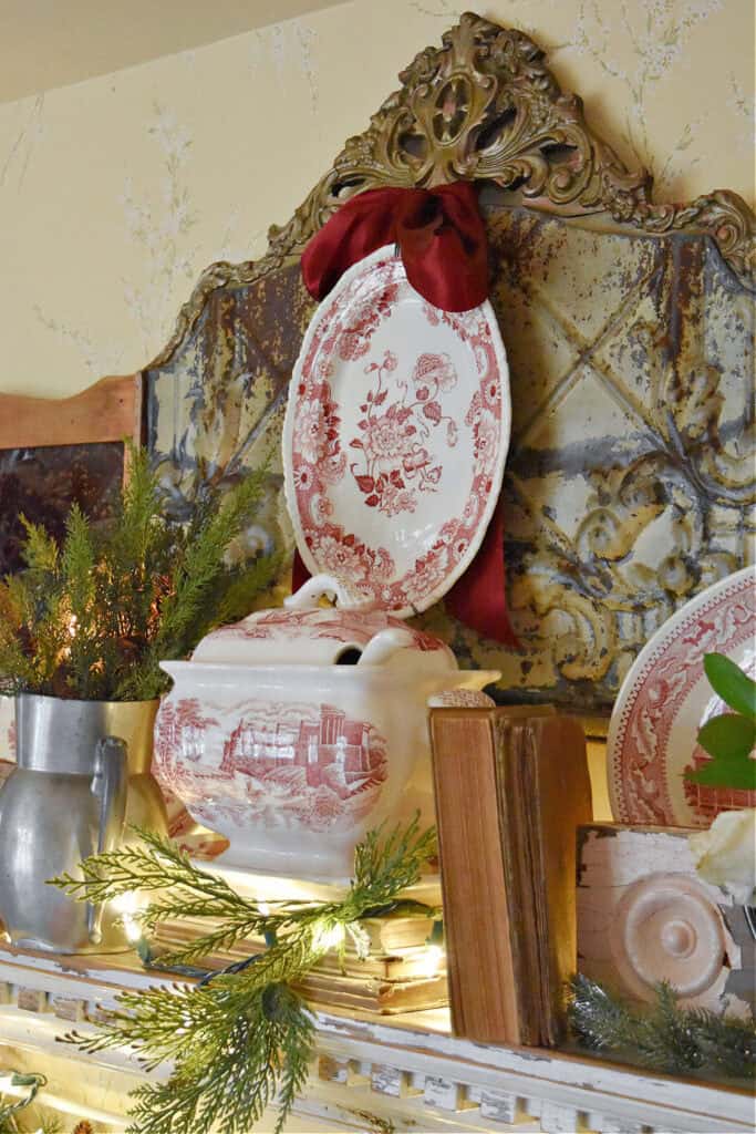 Red and white transferware decorated for Christmas on shelf.