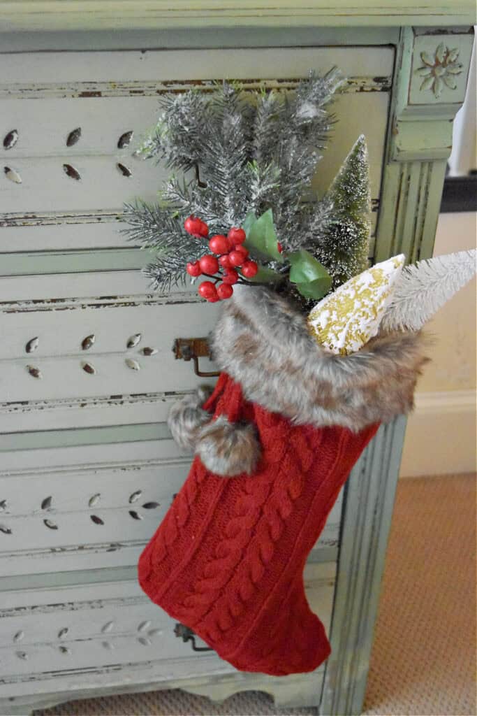 Red sweater Christmas stocking with bottle brush trees.