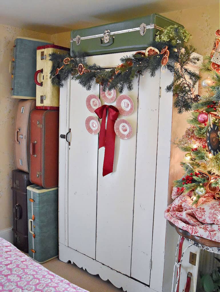 Vintage suitcases stacked in Christmas decorated bedroom.