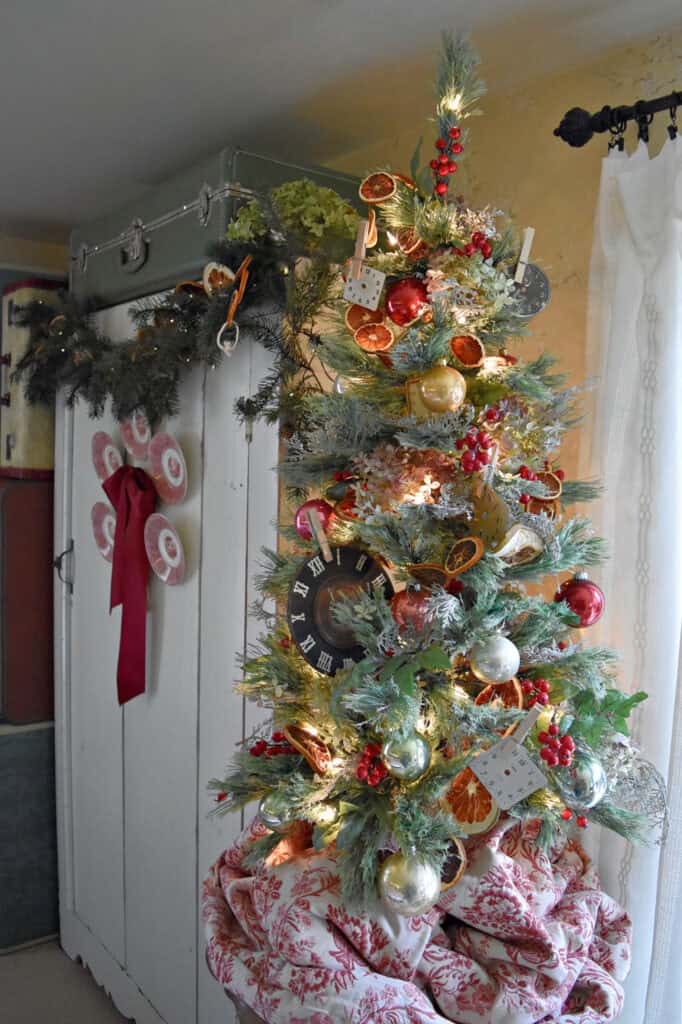 Decorated Christmas tree with clock faces, orange slices and hydrangeas.