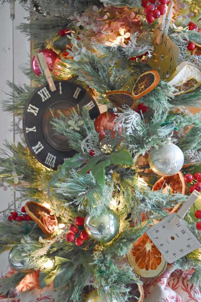Antique clock face on decorated Christmas tree.