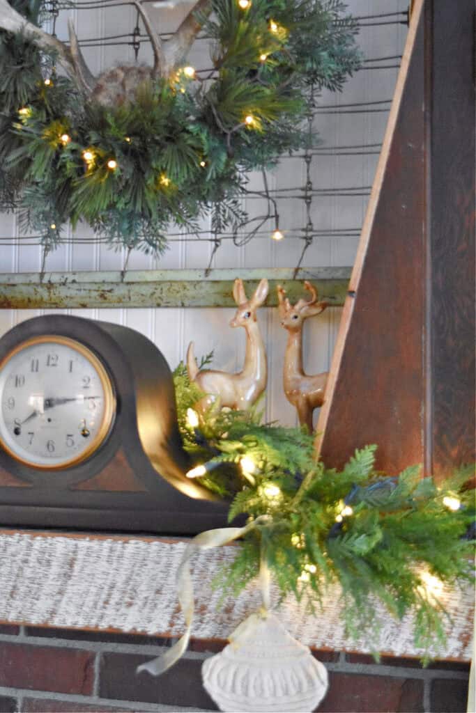 Deer figurines on mantel with vintage clock.